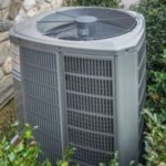 Air conditioning unit surrounded by greenery, illustrating proper AC maintenance for improved indoor air quality and humidity control in homes.